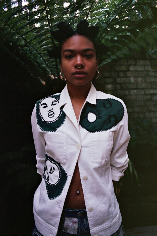 A model showcasing a white shirt with Ophelia's embroidery on